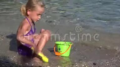 4K孩子在沙滩上玩耍，孩子在海滨的波浪中玩耍，女孩在海岸上建造城堡湾